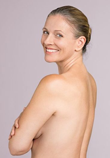 Eine Frau posiert für ein Foto und zeigt ihre natürliche Schönheit.